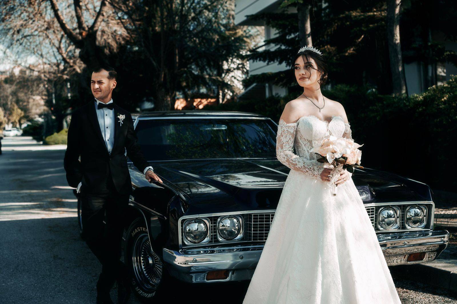 A wedding couple standing beside a black limousine at a Mississauga banquet hall
