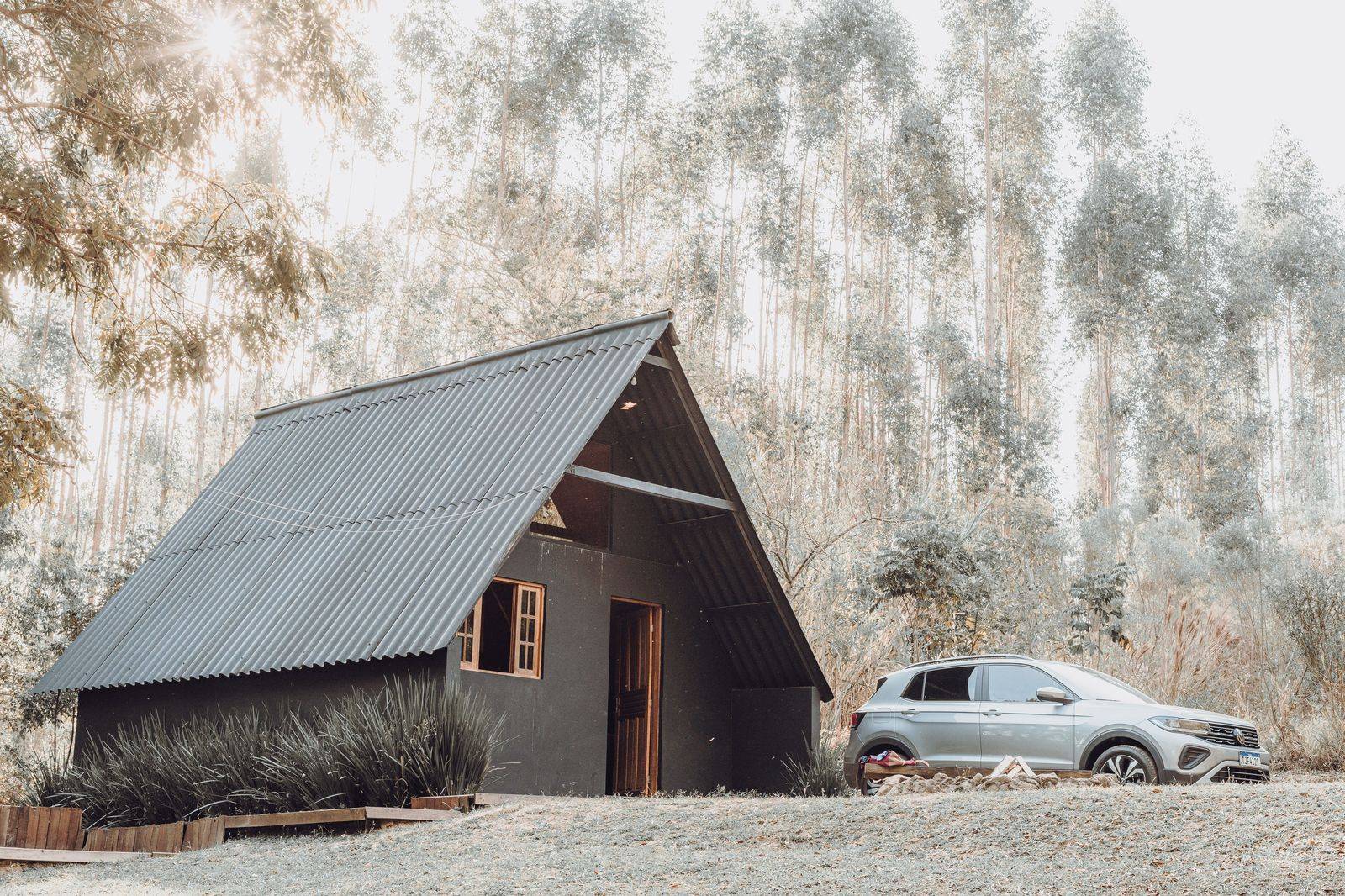 A black SUV parked in a forested cottage driveway in Muskoka