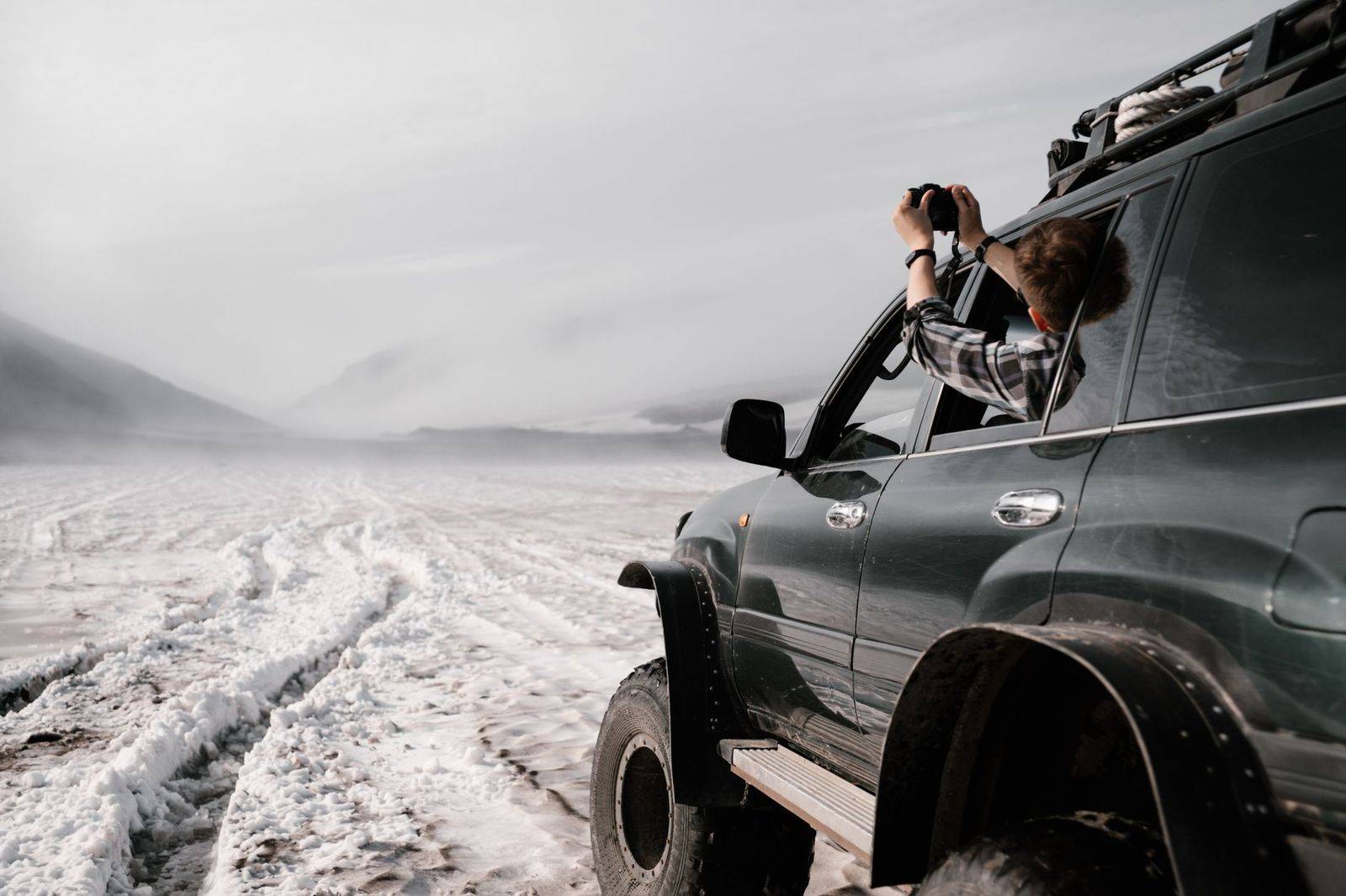 A black SUV driving north on a snowy highway towards Newmarket and Aurora