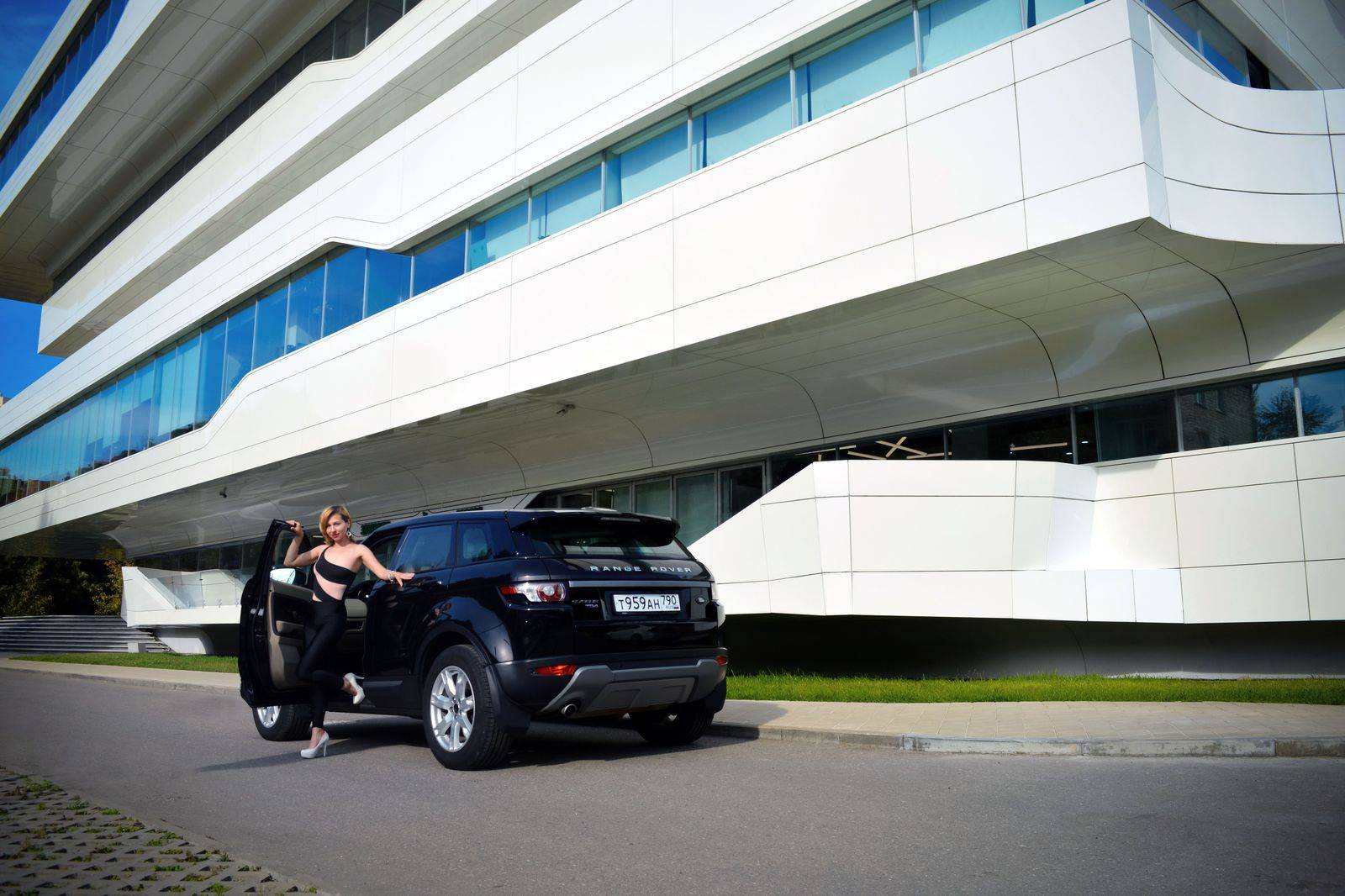A black SUV parked outside the condo towers of North York Centre, ready for a Pearson departure