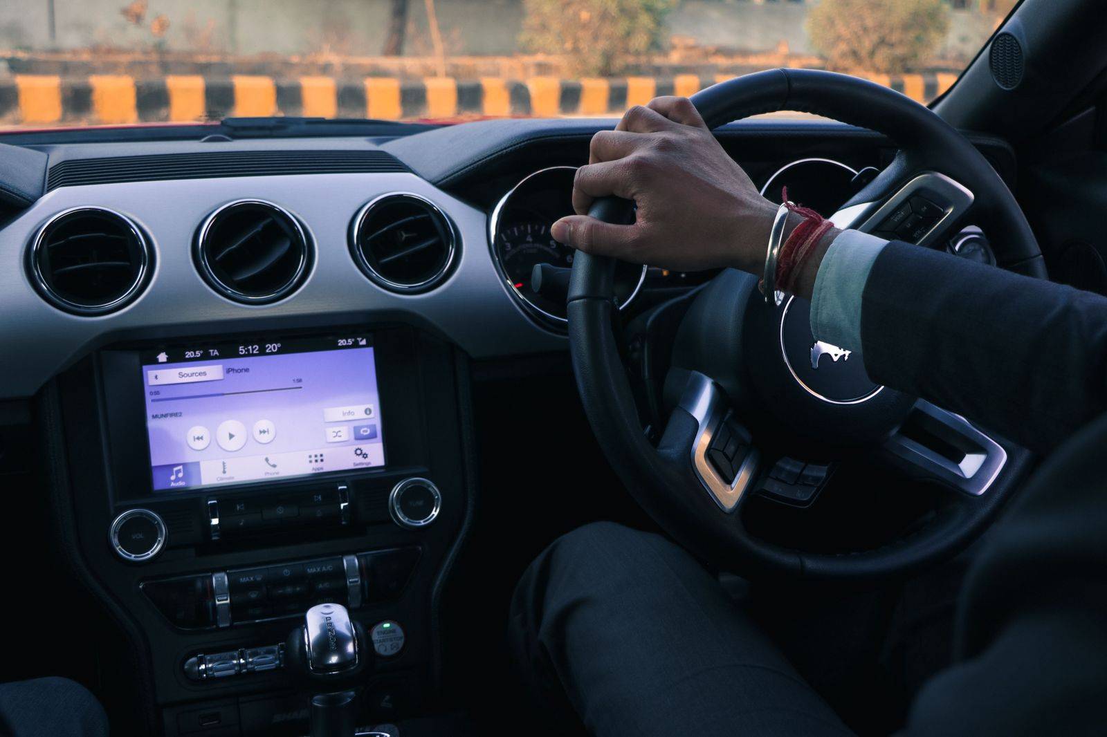 Chauffeur's hands on the wheel of a black luxury car on a Toronto highway