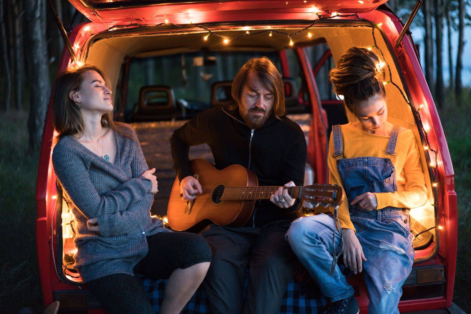 Group of friends stepping into a black van after a summer concert