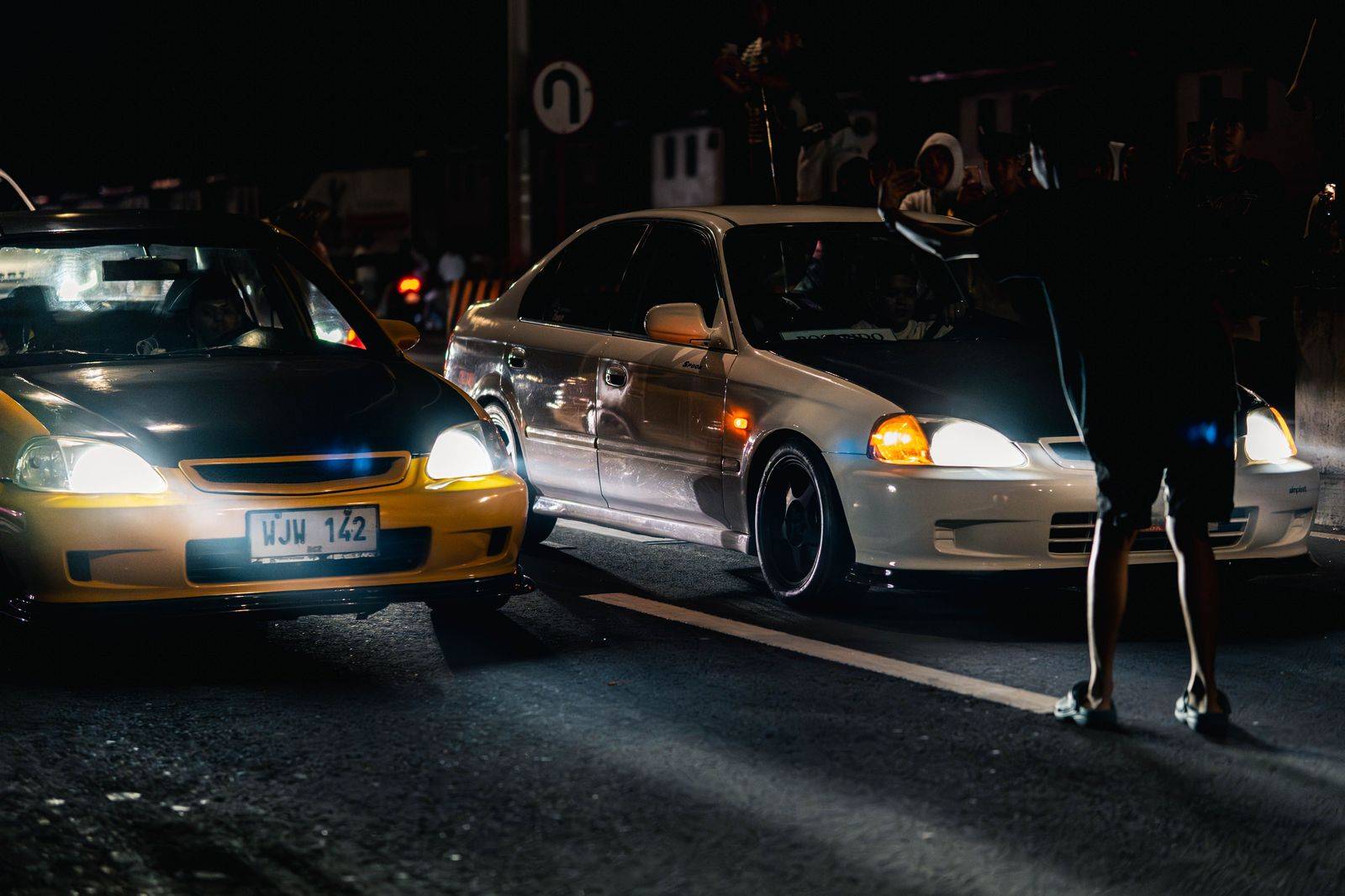 A black sedan waits on a side street for passengers walking back from the Canada Day fireworks