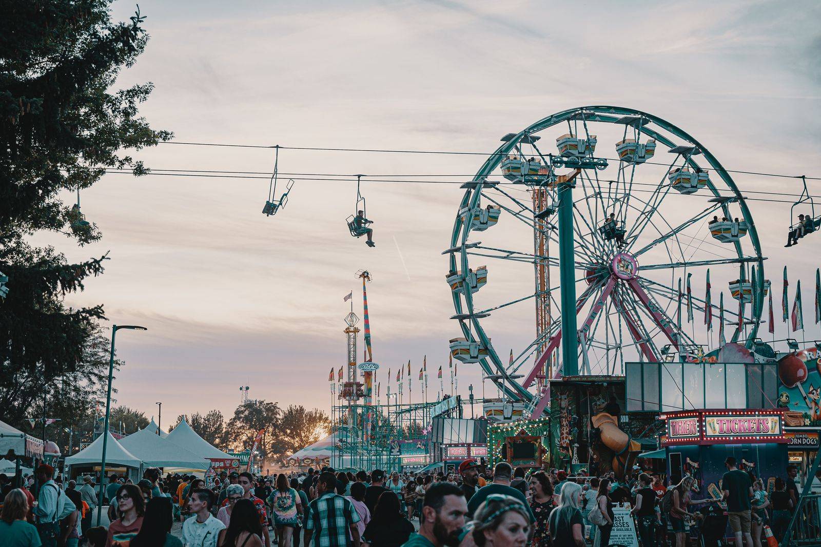 Families walking through a summer fair crowd, the kind of end-of-day exit a chauffeur makes easier