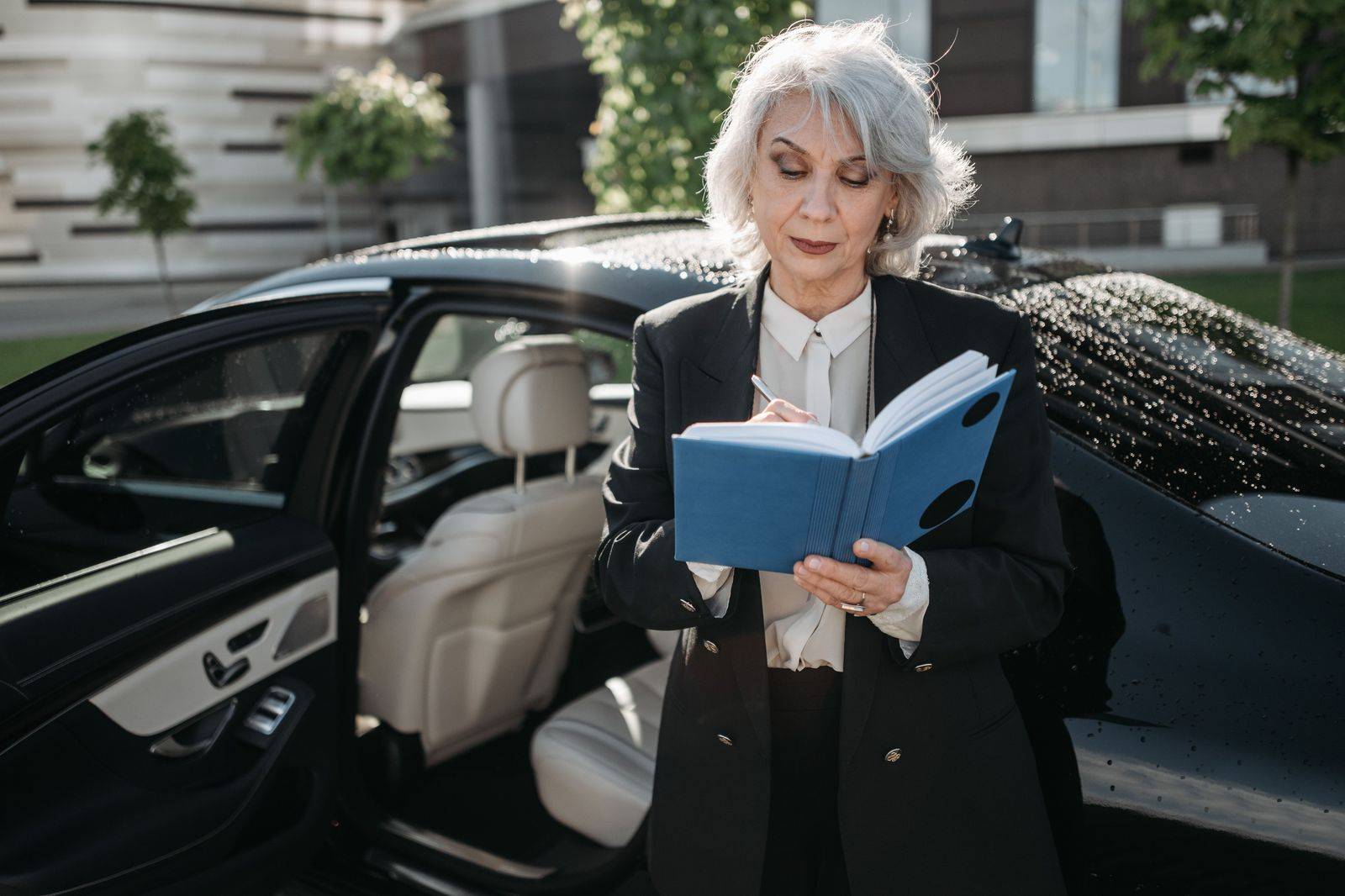 Chauffeur opening the rear door of a black car on race day