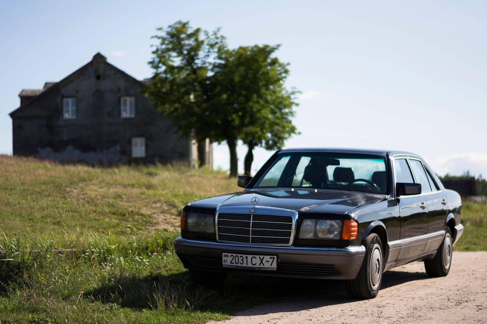 Black sedan waiting outside a stadium on a summer evening