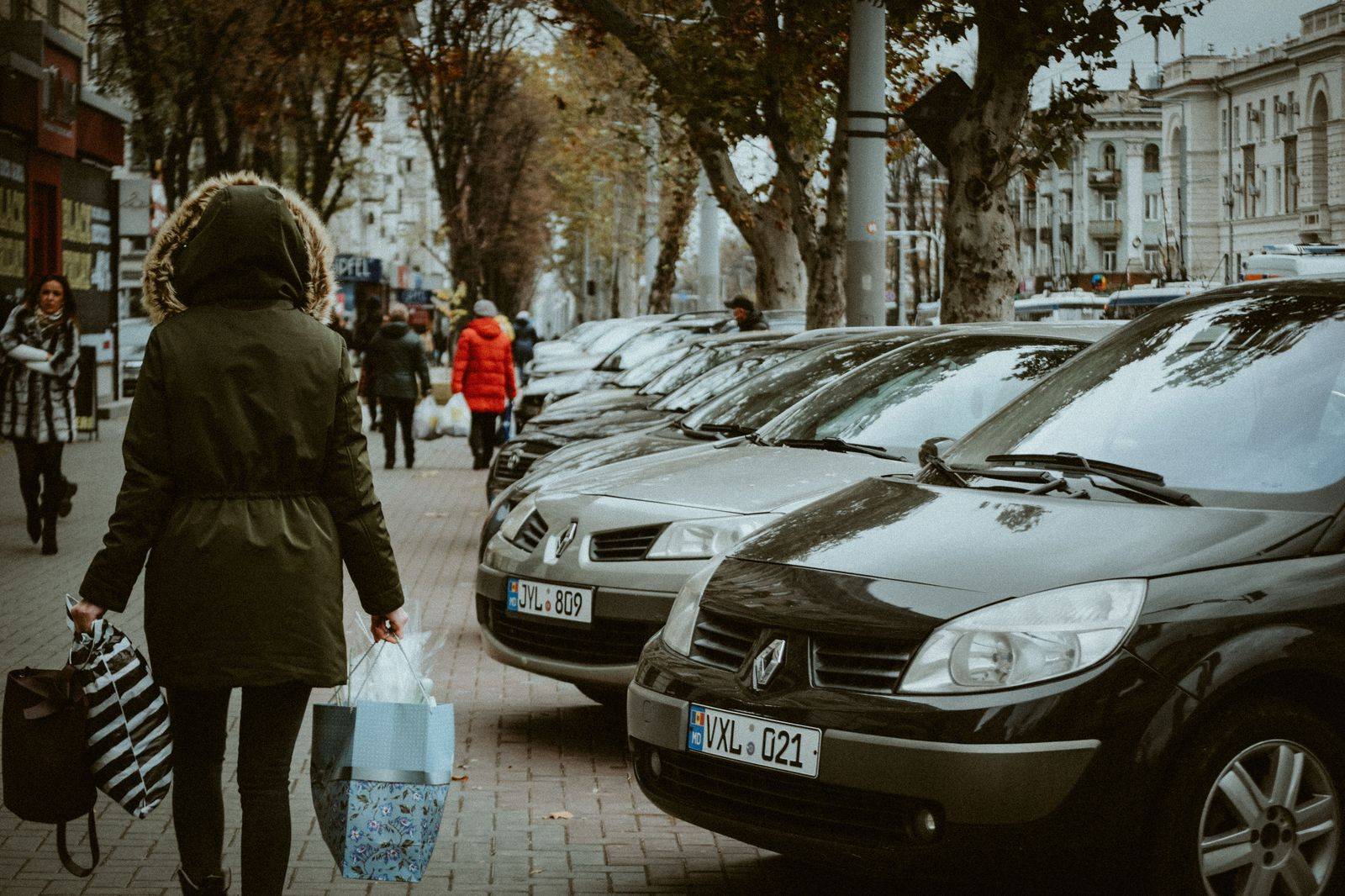 Shopping bags and wrapped gifts loaded into the trunk of a car on a winter day