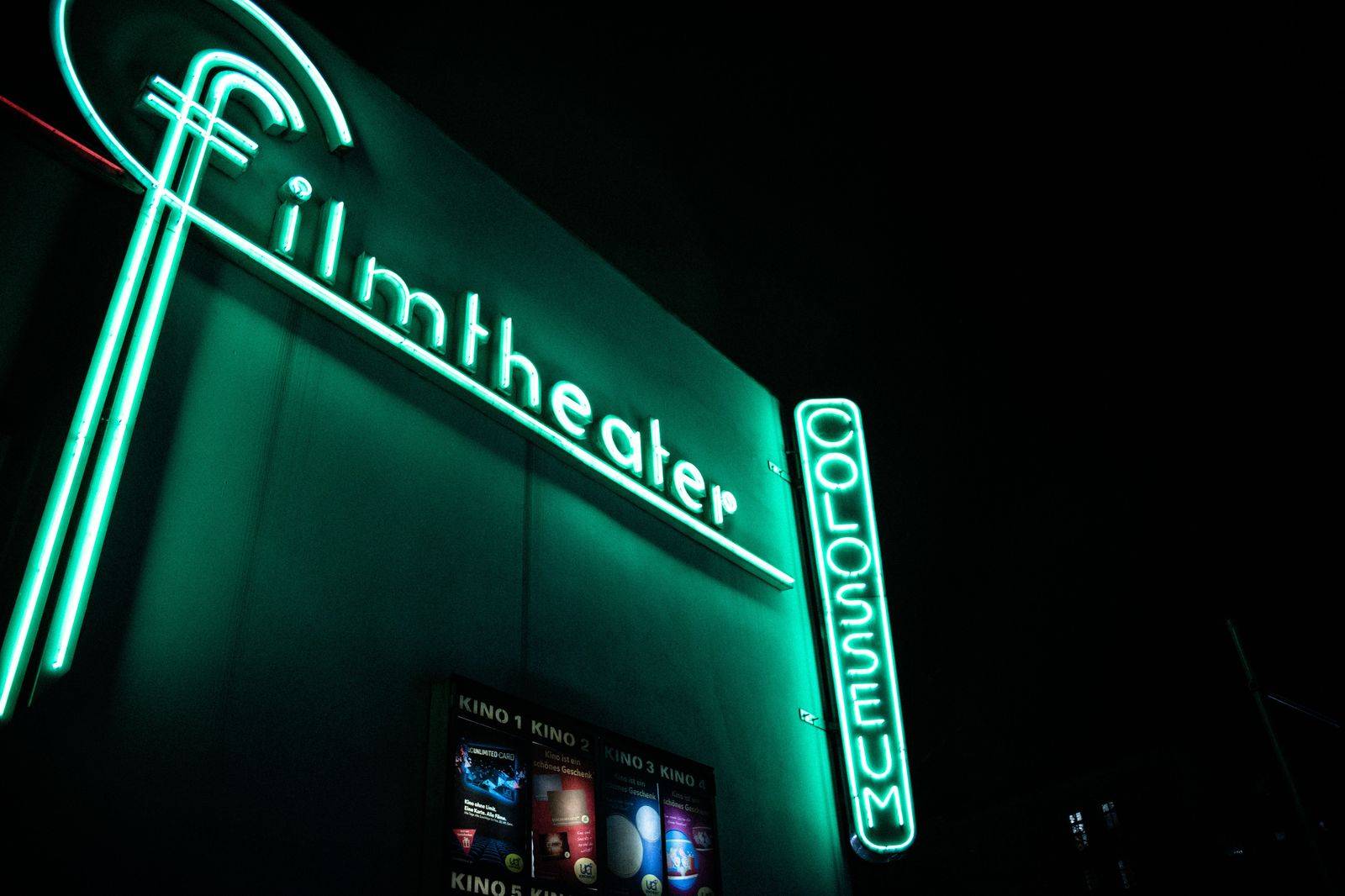 Cinema marquee lit up on a busy downtown street at night