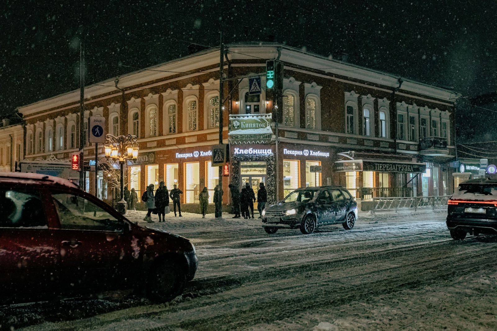 A black car on a snowy Toronto street at night, ready for a New Year's Eve pickup