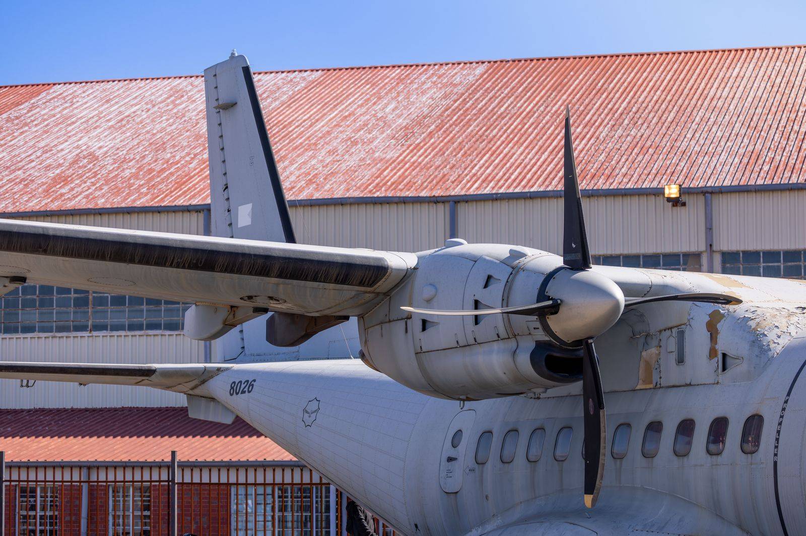 A turboprop aircraft parked outside a hangar at a city airport