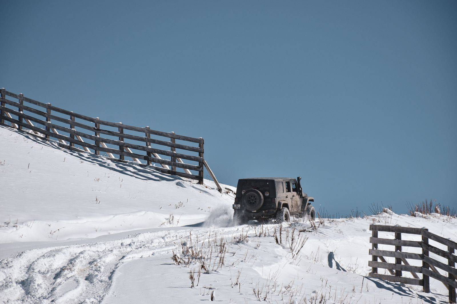 An executive SUV on a snowy road near the Blue Mountain ski hills