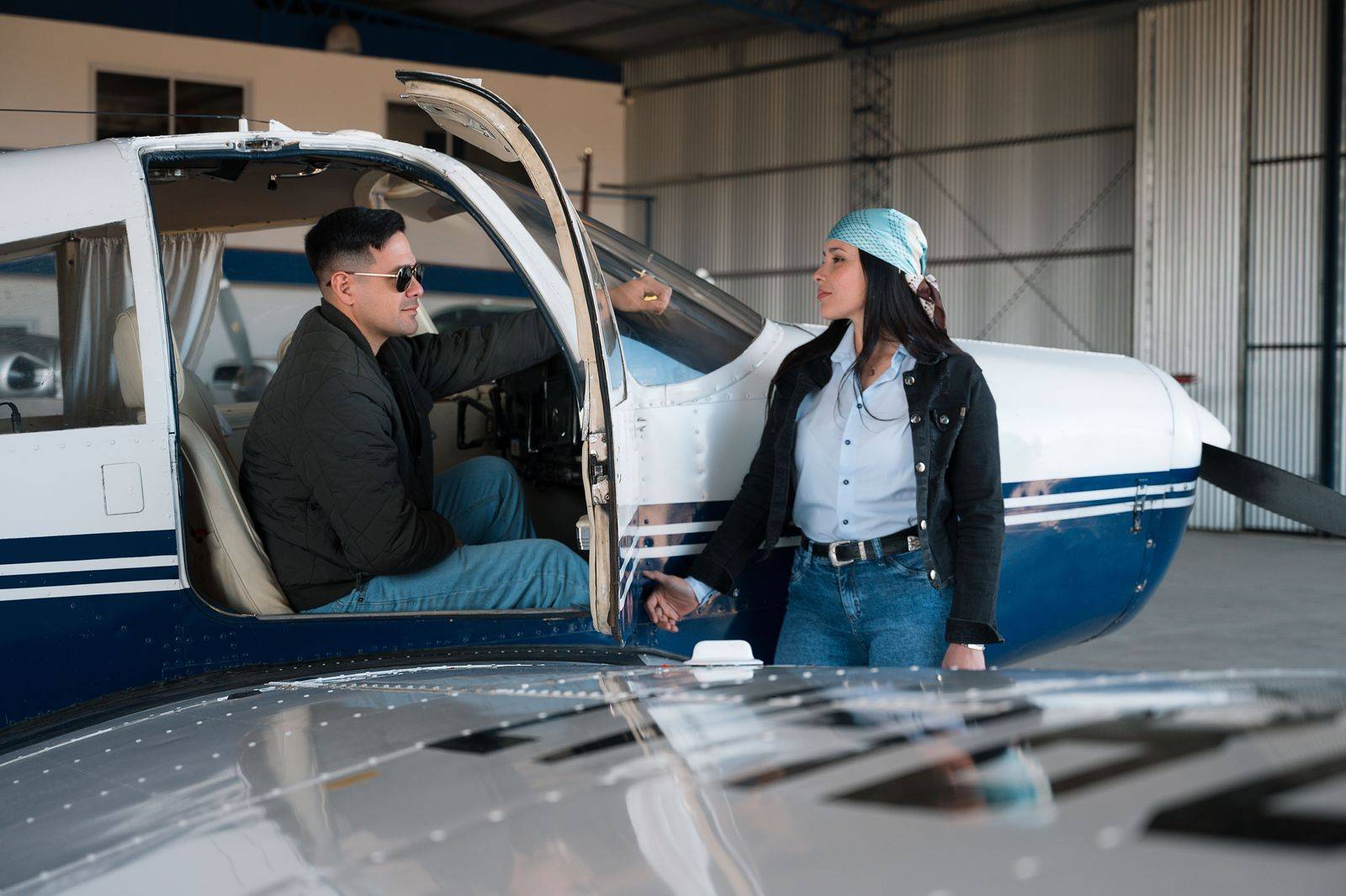 A pilot walking beside a private jet on the apron