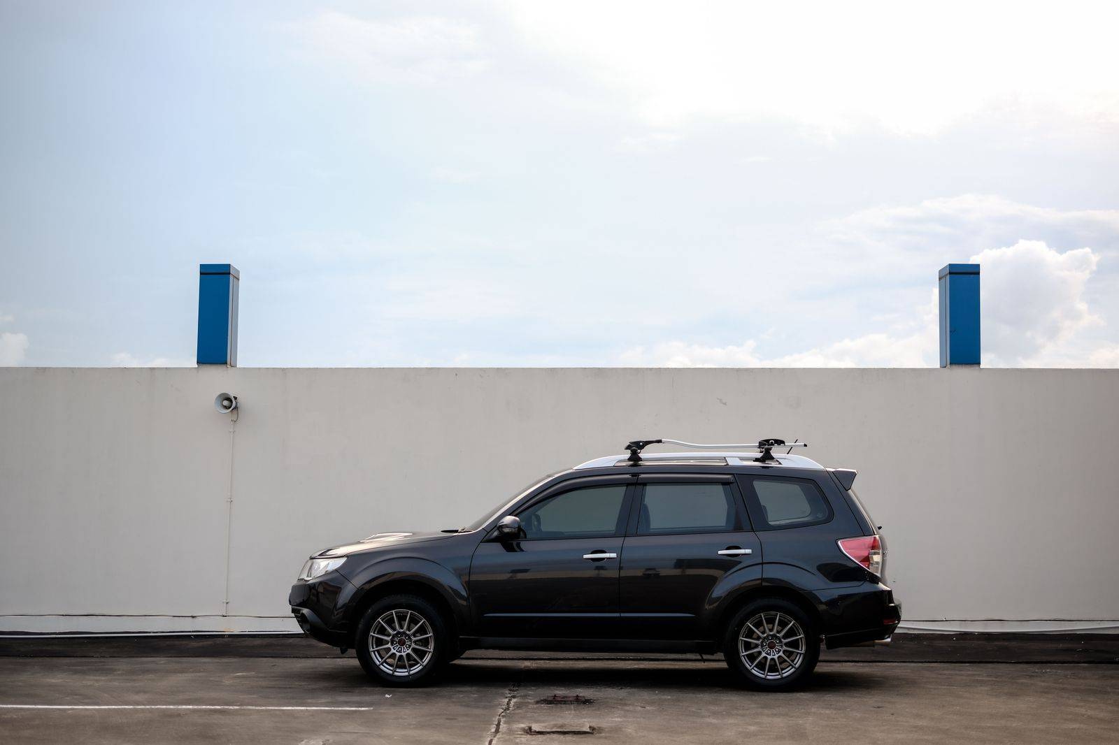 A black SUV waiting near a hangar at a regional airport