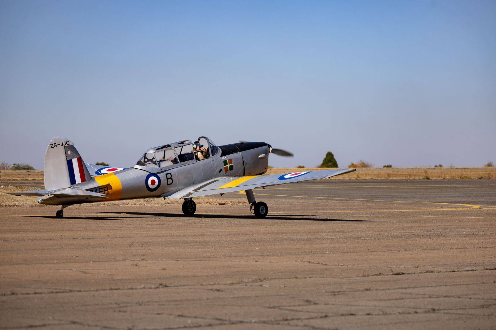 A pilot crossing the apron with a flight bag toward a waiting car