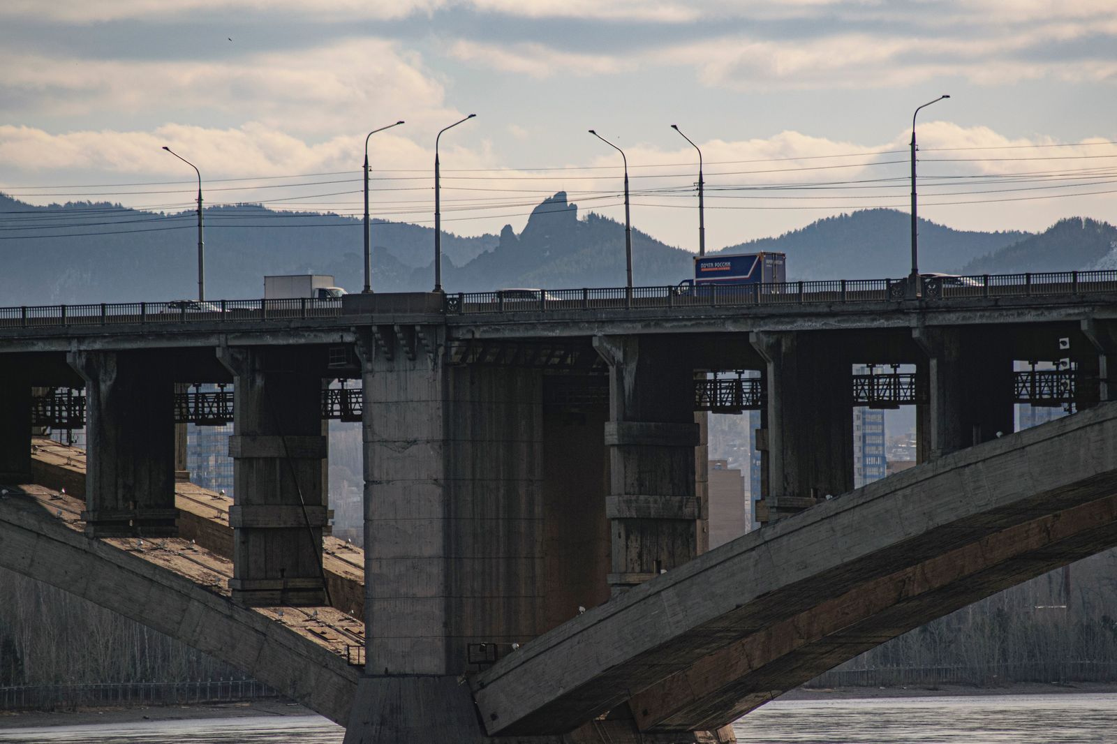 A black SUV crossing a river bridge on a chauffeured trip to the United States