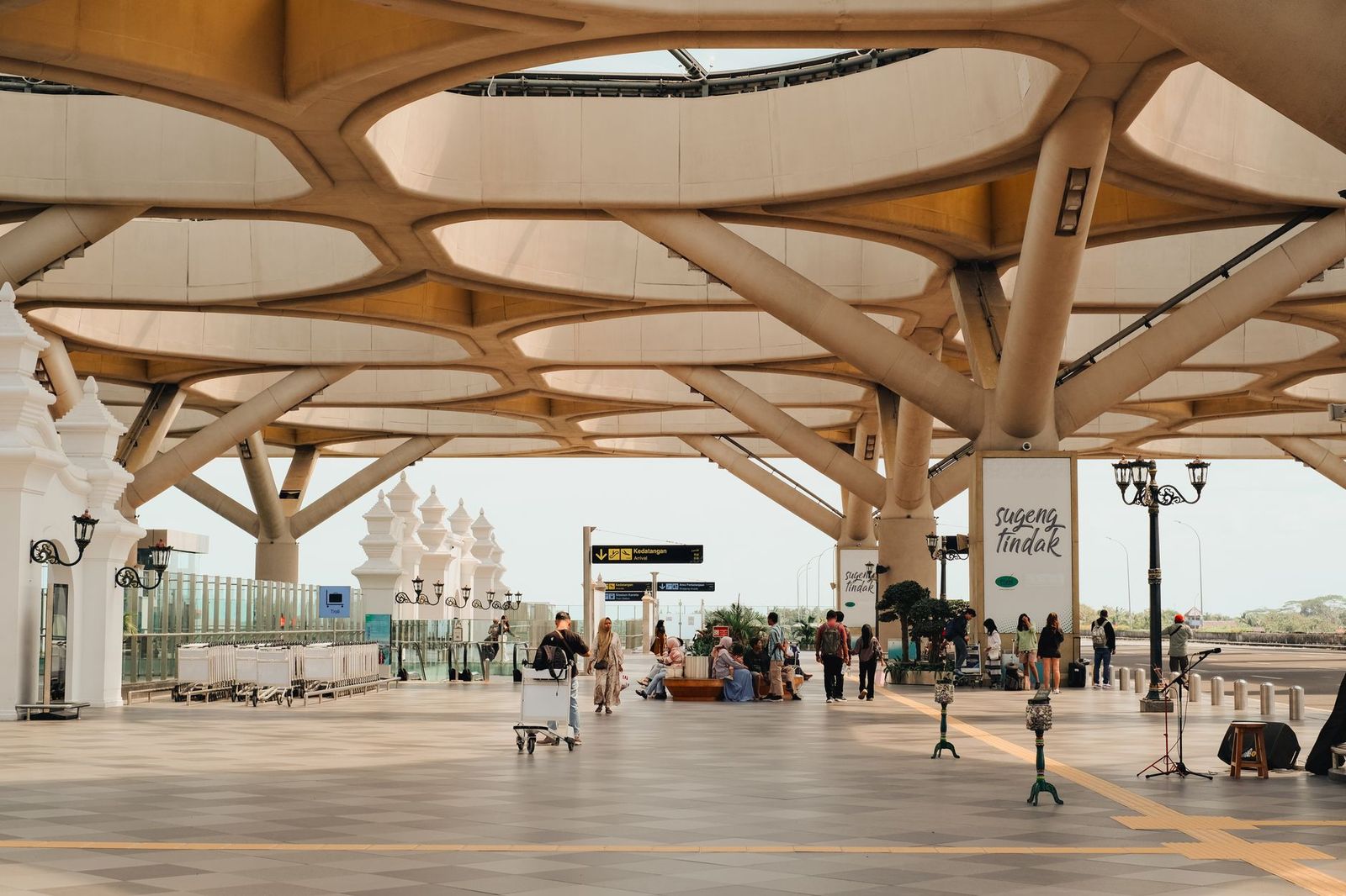 Check-in counters inside a large airport terminal with travellers queuing