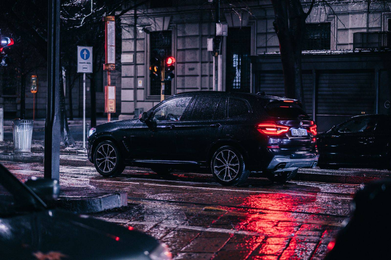 A black SUV waiting on a downtown Toronto street at night