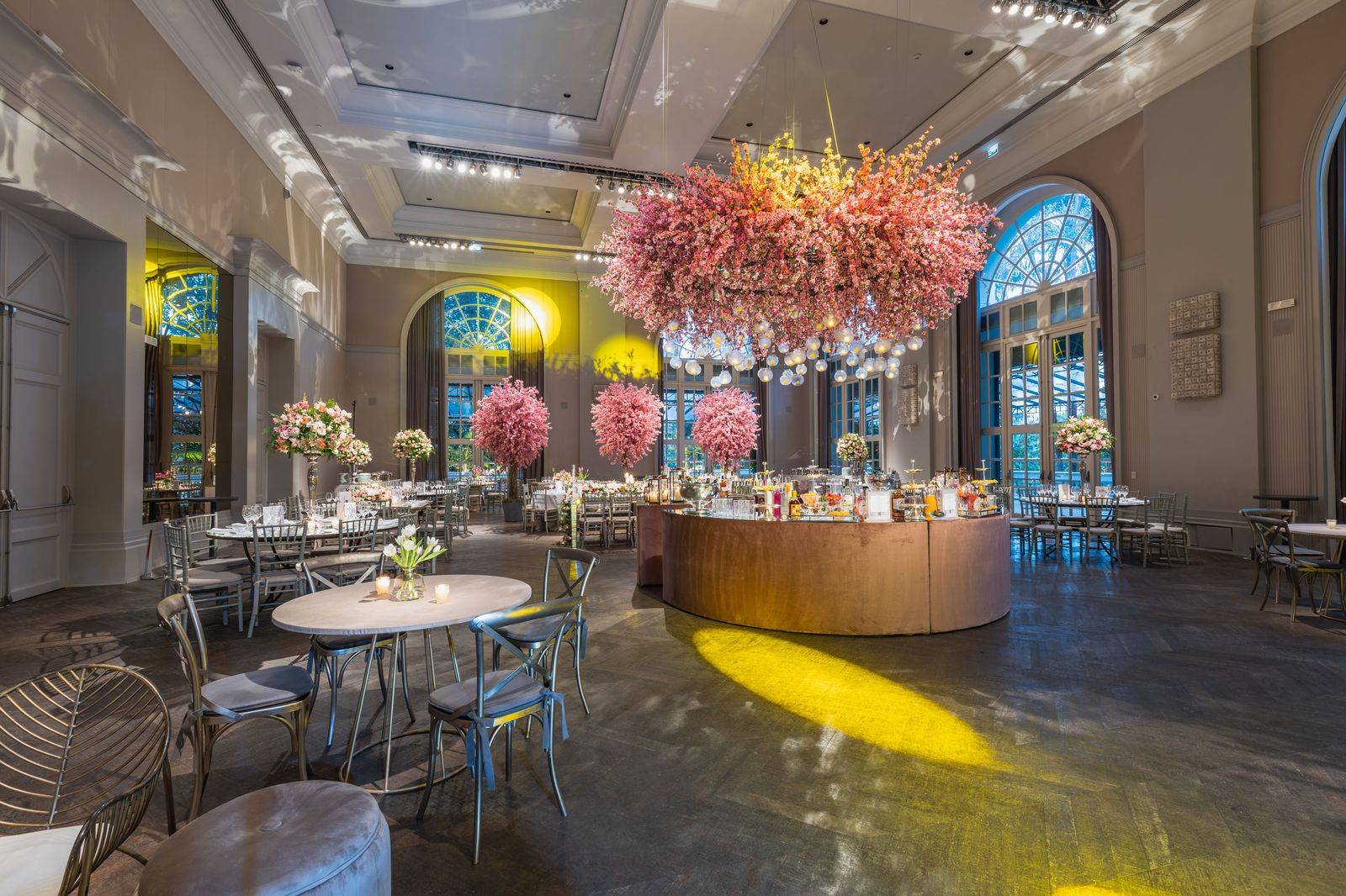 A ballroom set for a black-tie dinner, the kind of evening where hourly chauffeurs wait outside until the last speech