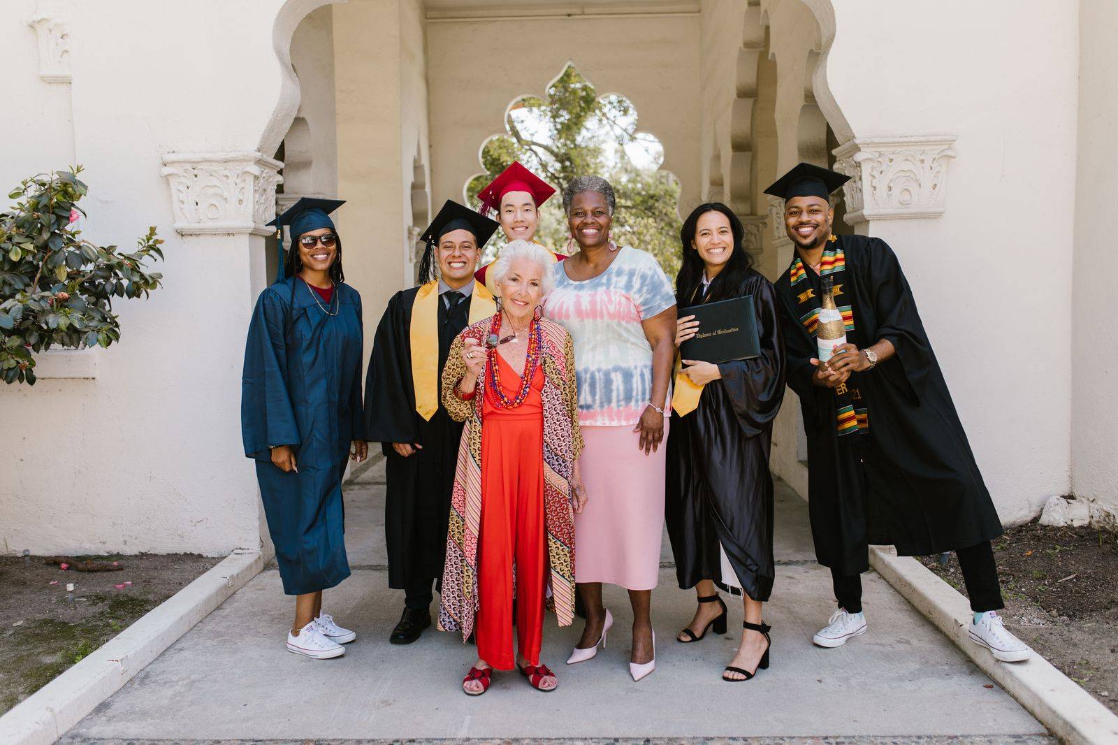 A graduate in a gown with family before the chauffeur drives them to lunch in Toronto