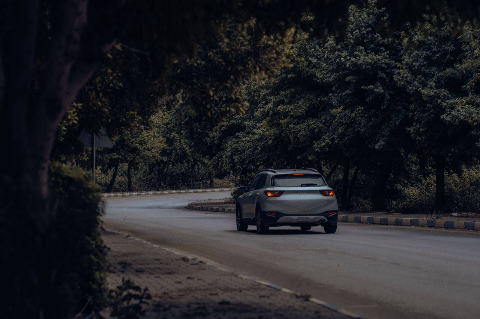 A black SUV on a forested two-lane highway on the way to Muskoka in summer