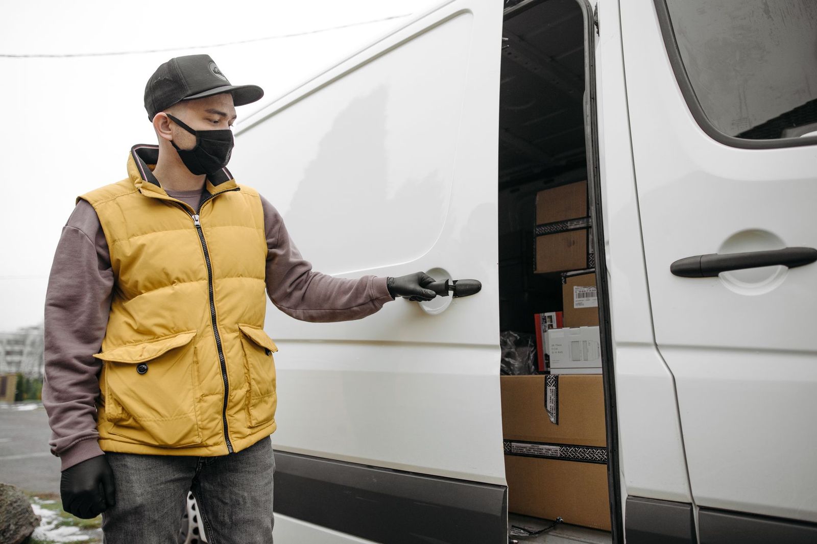 Chauffeur opening the rear door of a black car for a passenger