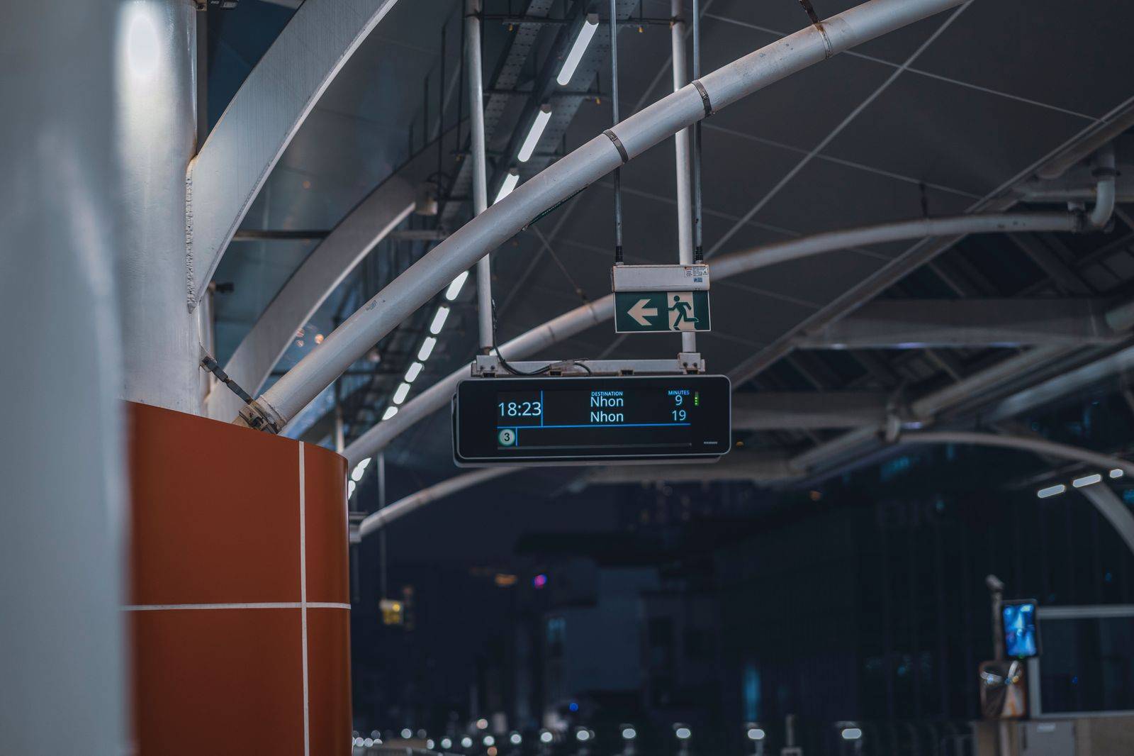Arrivals-level curb at a busy airport terminal at night, where pre-arranged cars pick up