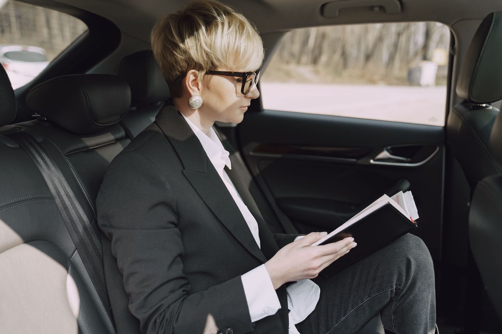A passenger reading in the back seat while a Toronto chauffeur drives through the city
