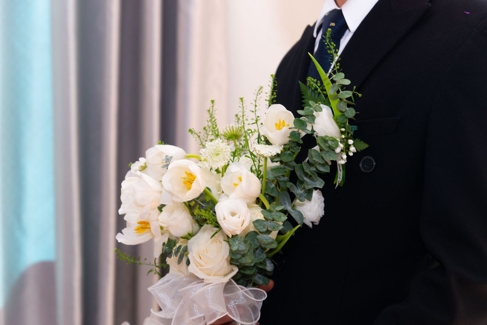 A prom couple poses for photos with a corsage and boutonniere before the limo arrives
