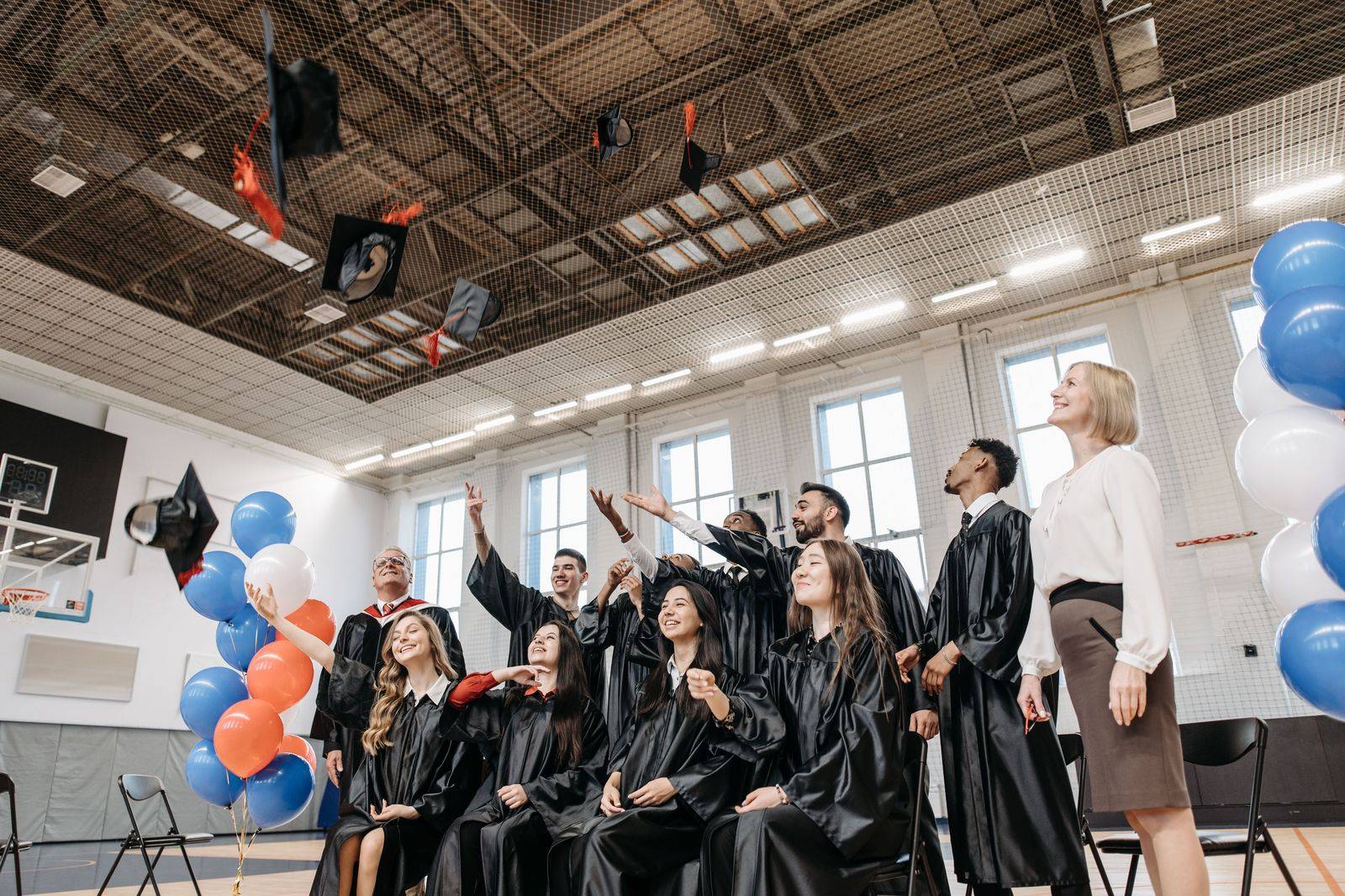 Graduates throw their caps in the air after a high school graduation