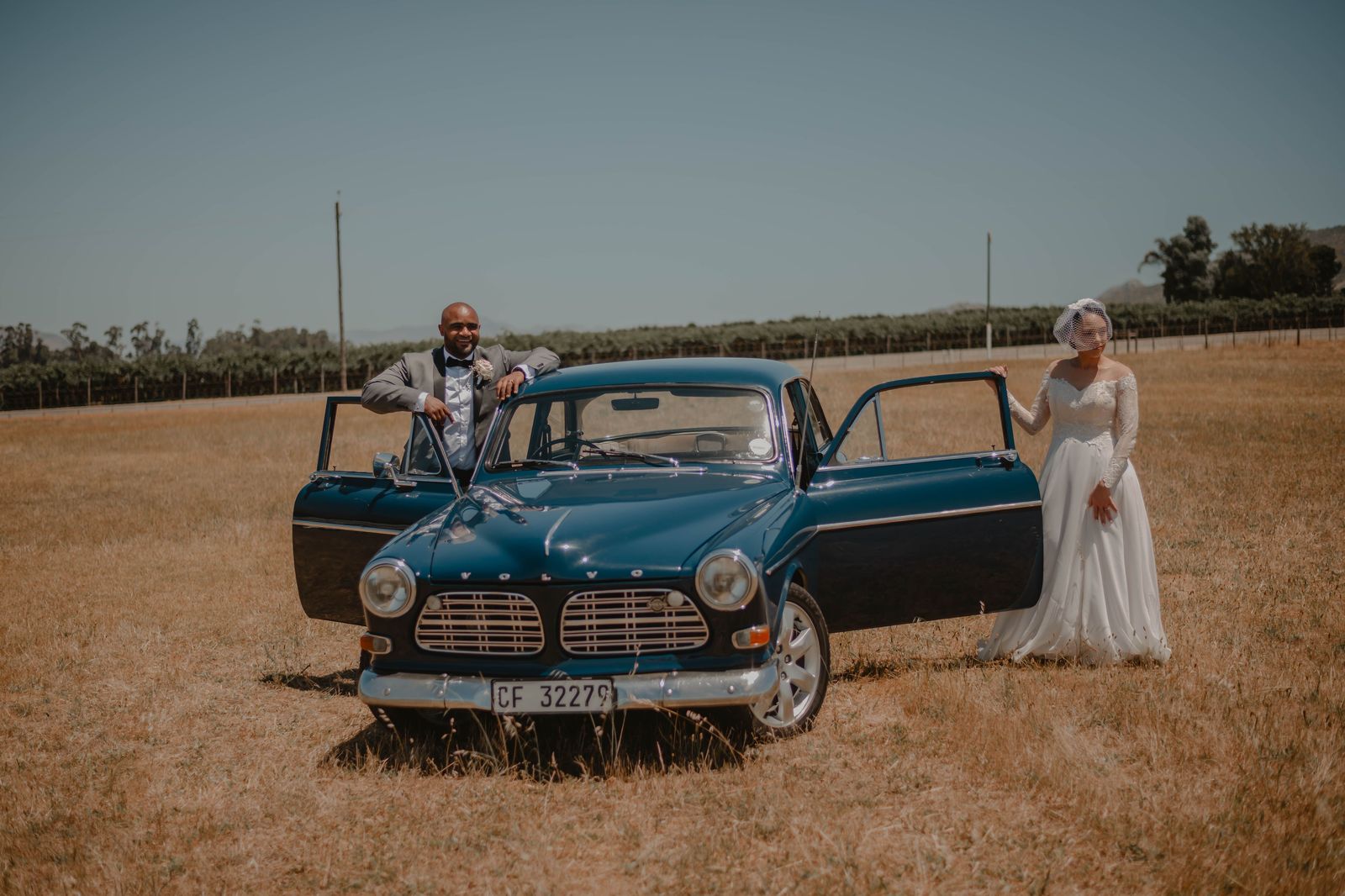 A couple stepping out of a black car on their way to a wedding reception